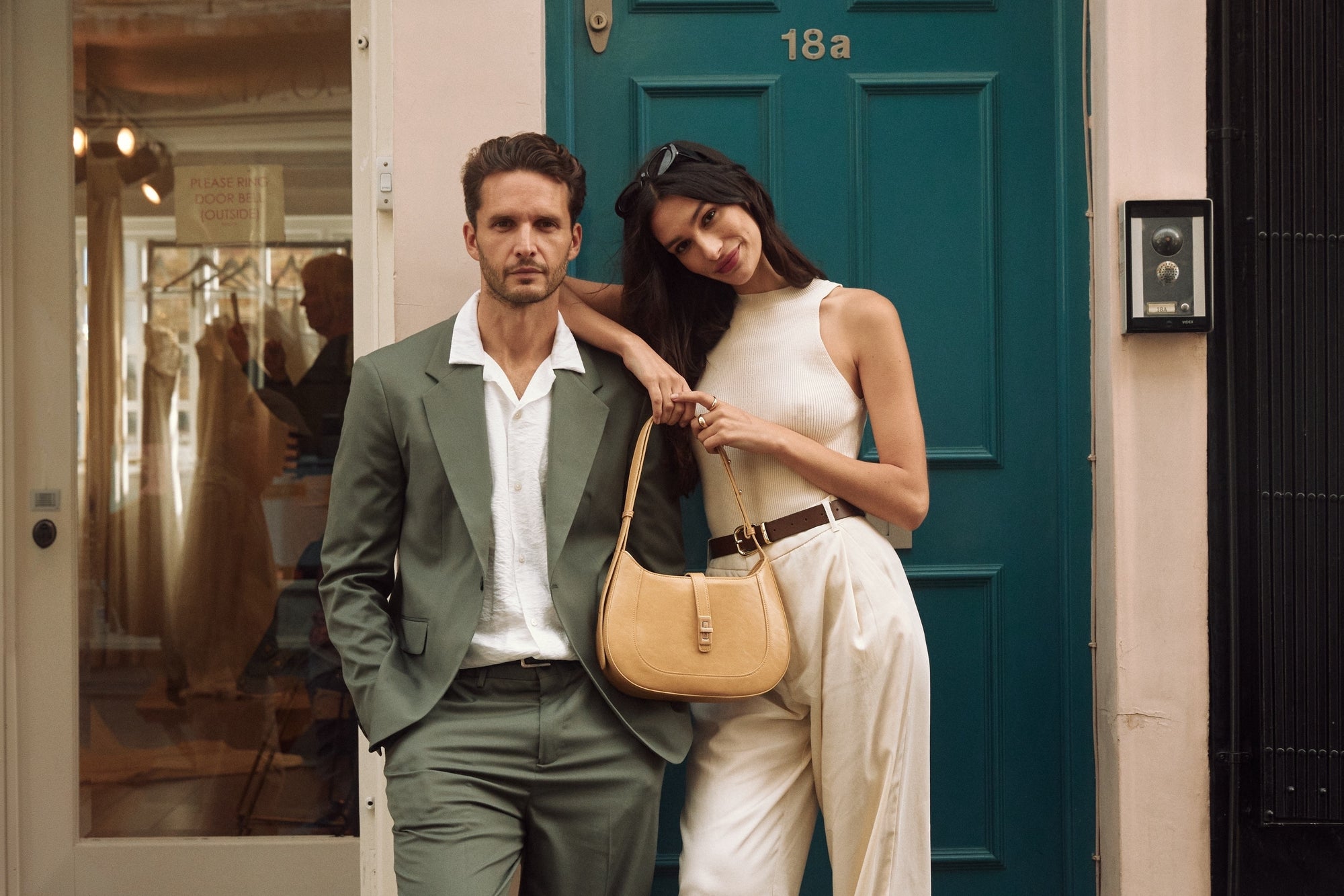 A contemporary couple standing together with an MJade handbag.
