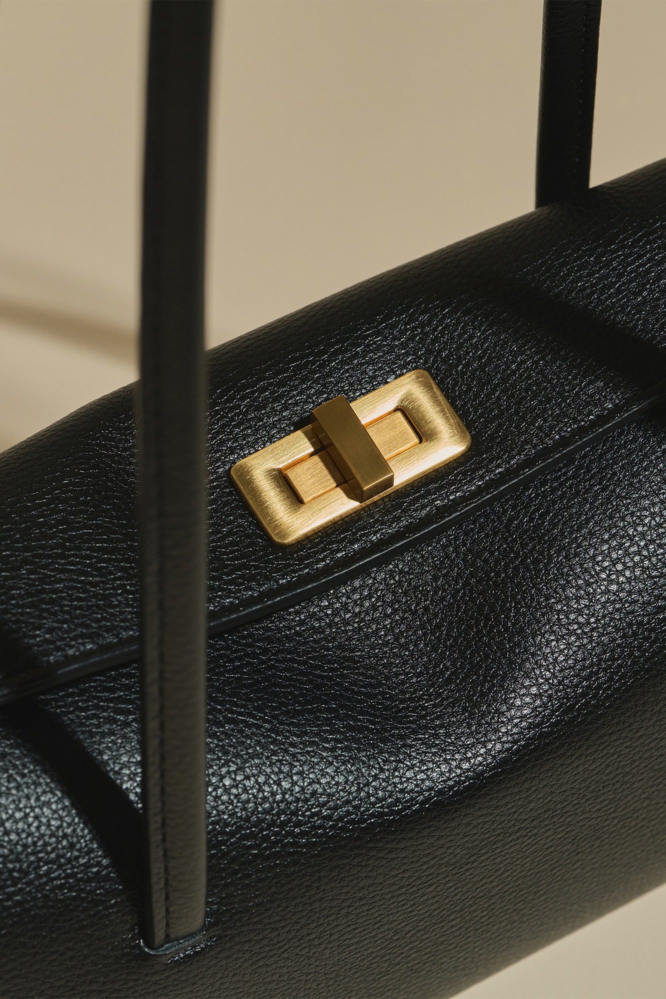Close-up of MJade\u2019s brushed gold rectangular buckle.