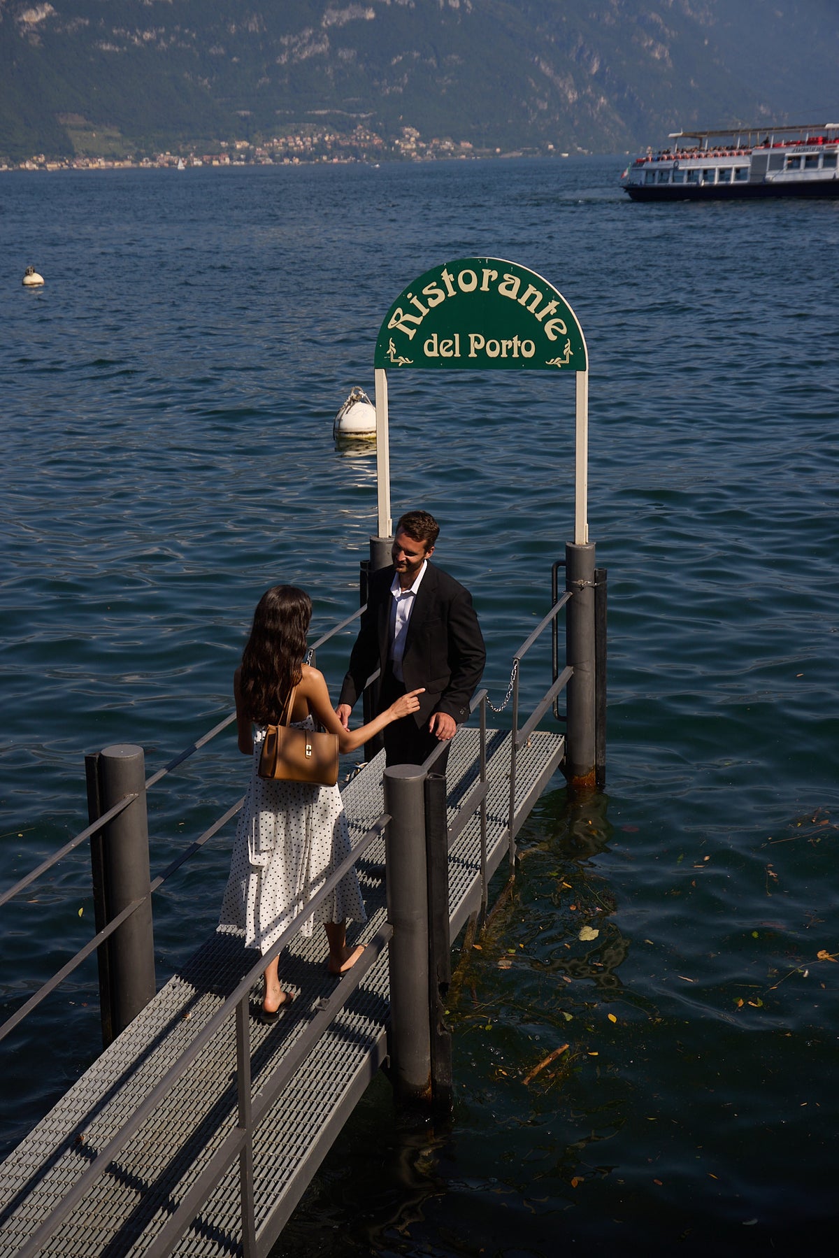 A couple meets on a waterfront gangway in Menaggio.
